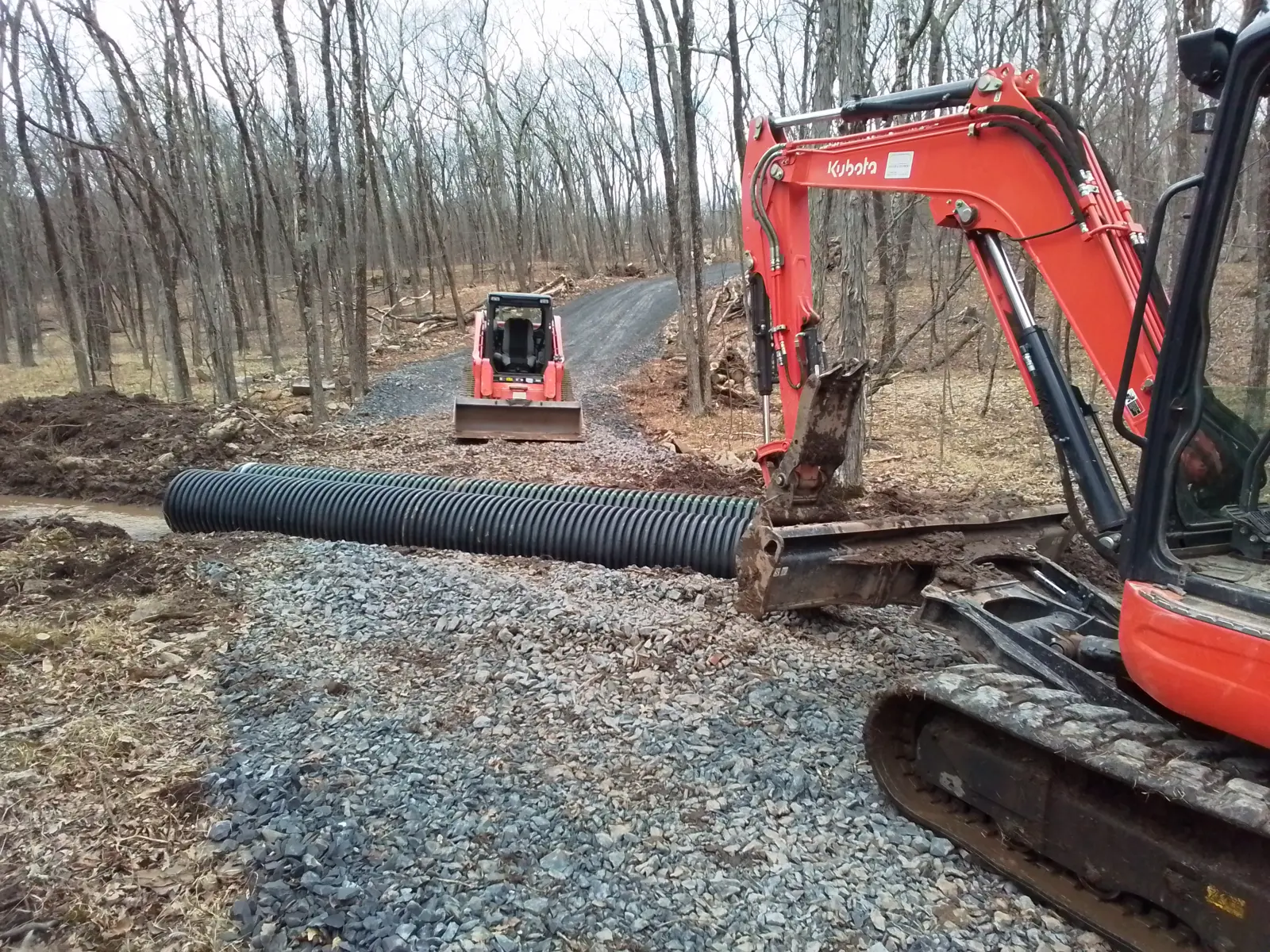 Gravel driveway being built on a compacted crushed stone base